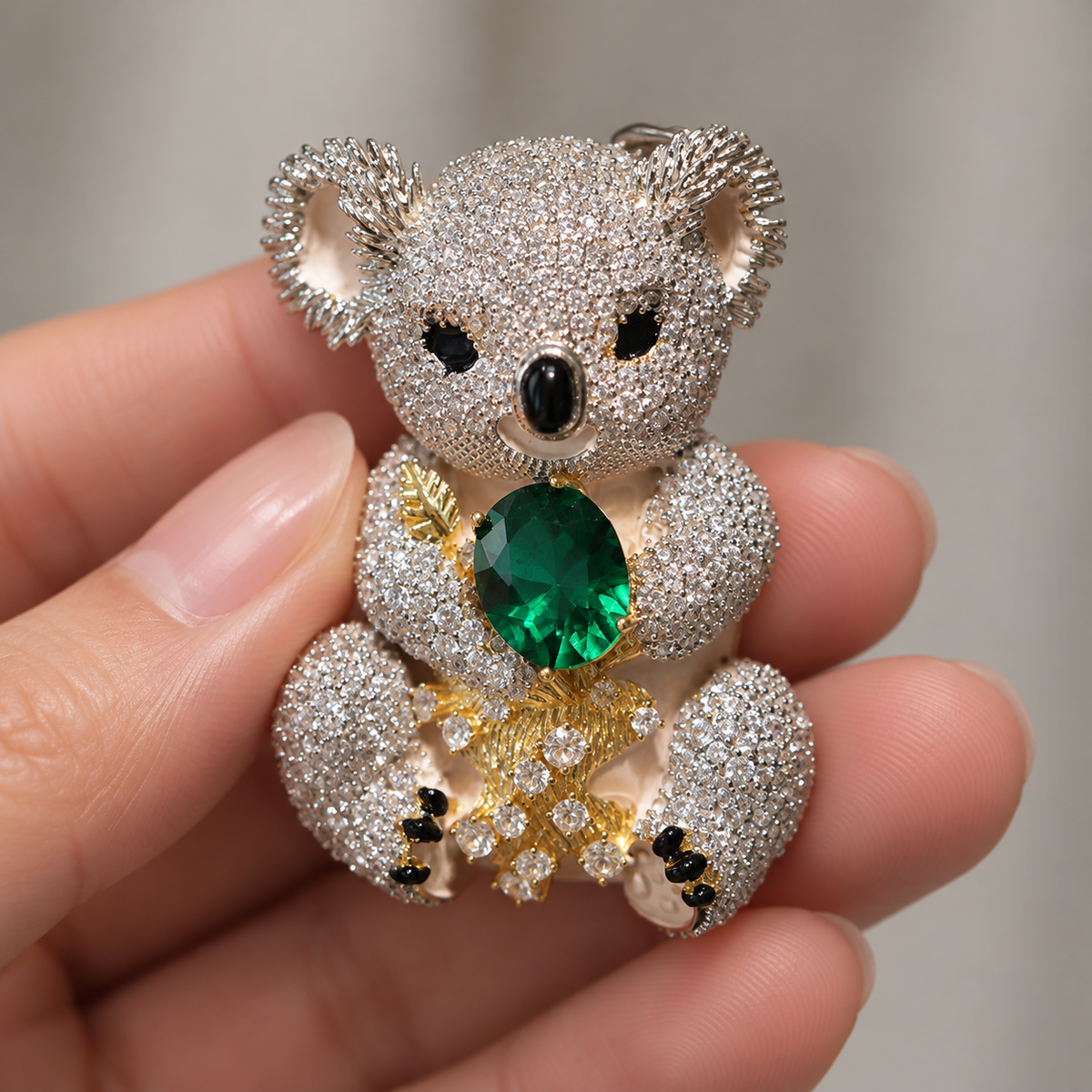 Emerald Green Koala brooch held in a hand