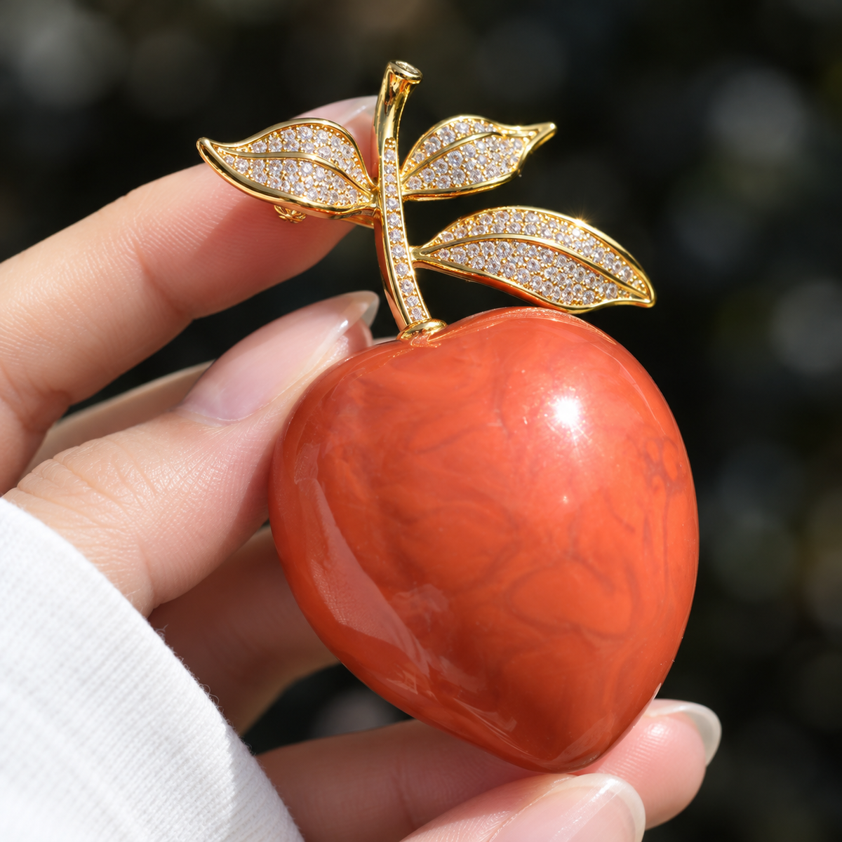 Vintage Peach brooch held in a hand