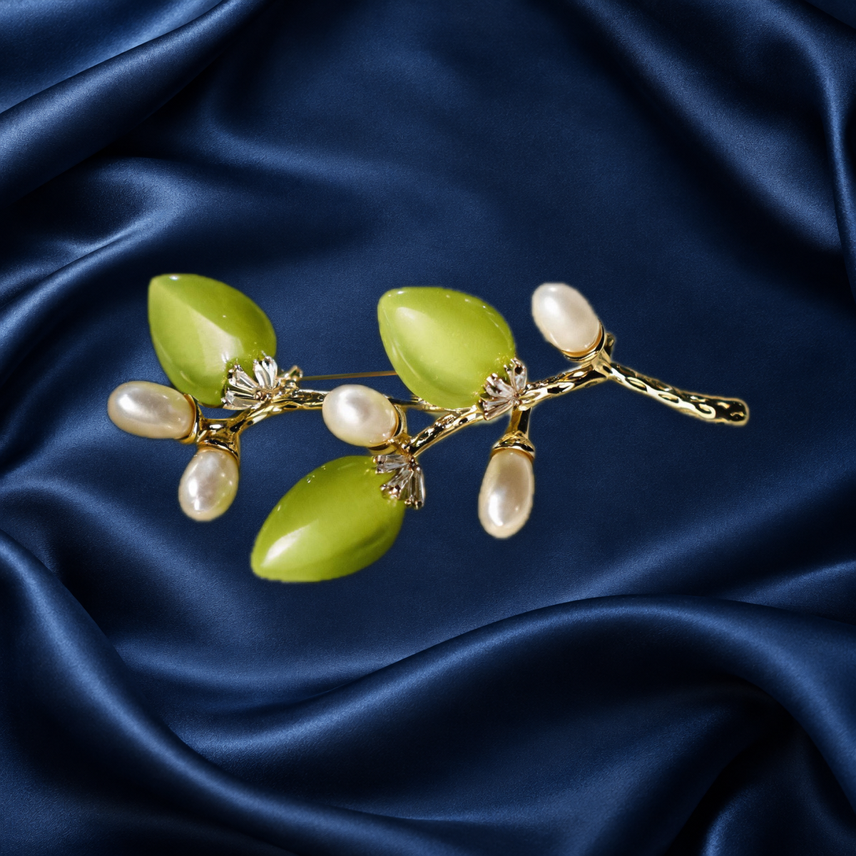 Green cat-eye stone flower branch brooch with freshwater pearls on navy satin