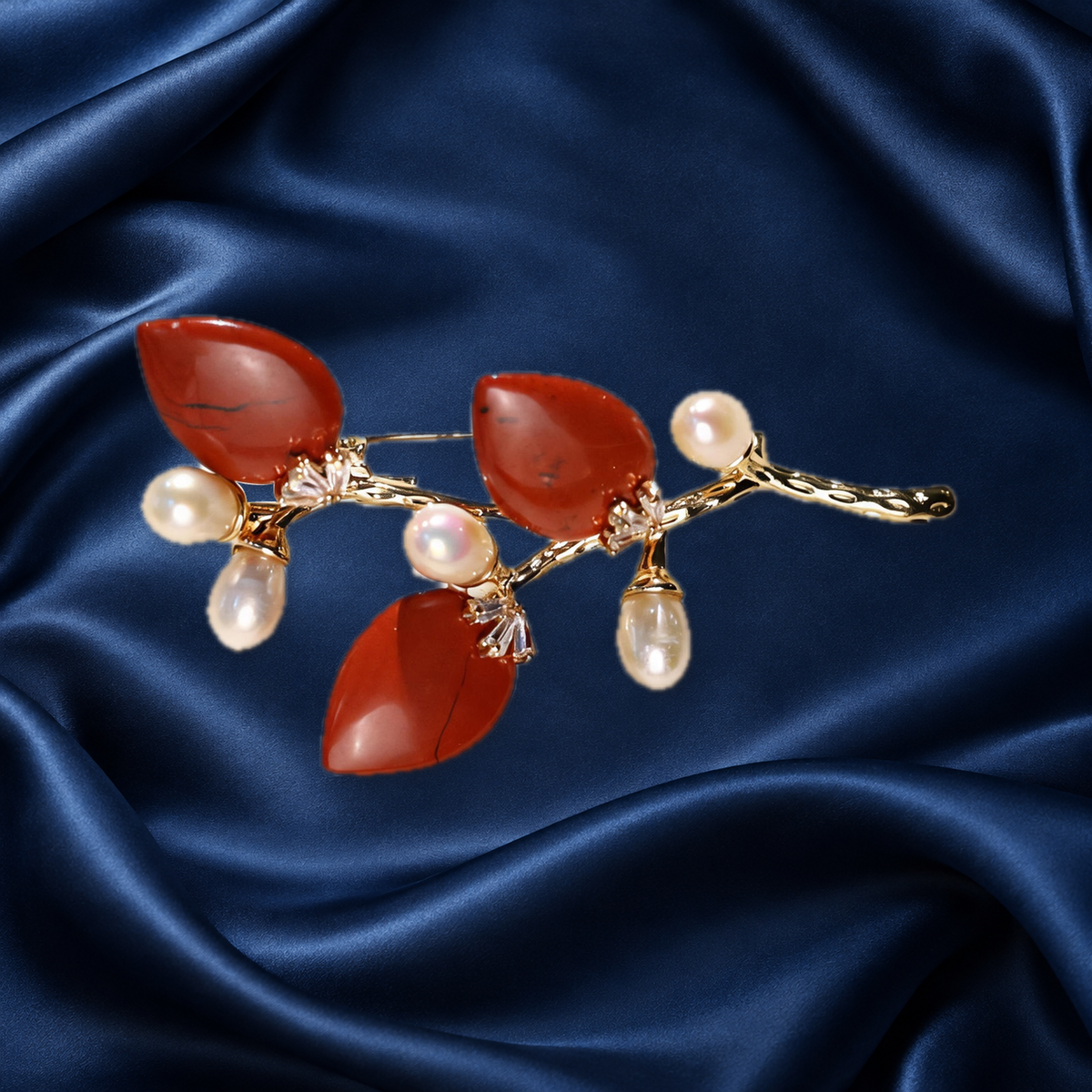Red natural stone flower branch brooch with freshwater pearls on navy satin