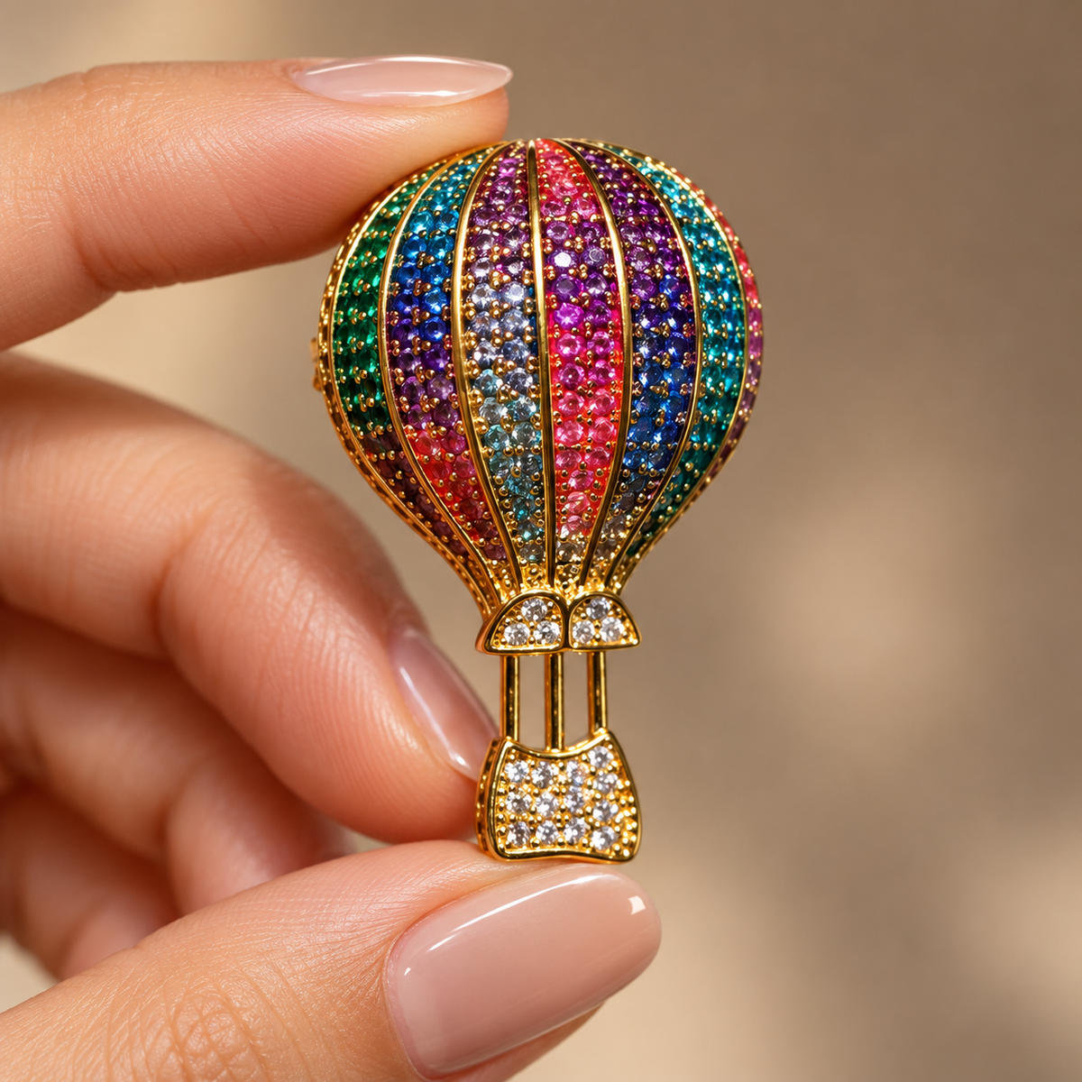 Gold Multicolor hot air balloon brooch and pendant held in a hand