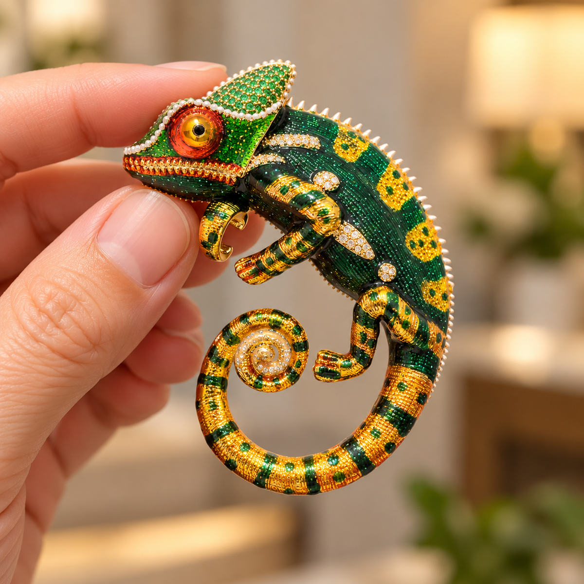 Green chameleon brooch held in a hand