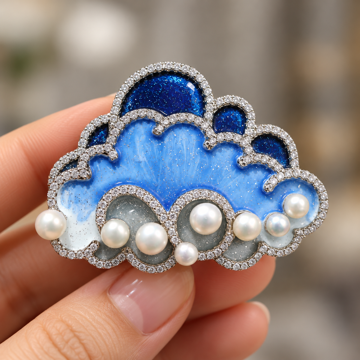 Blue cloud brooch held in a hand