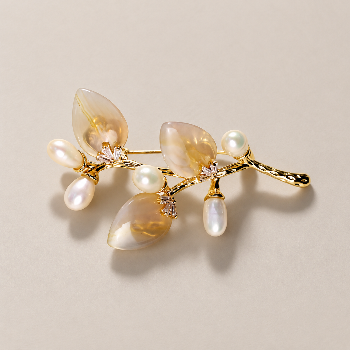 Gold White natural stone flower branch brooch with freshwater pearls on a neutral background