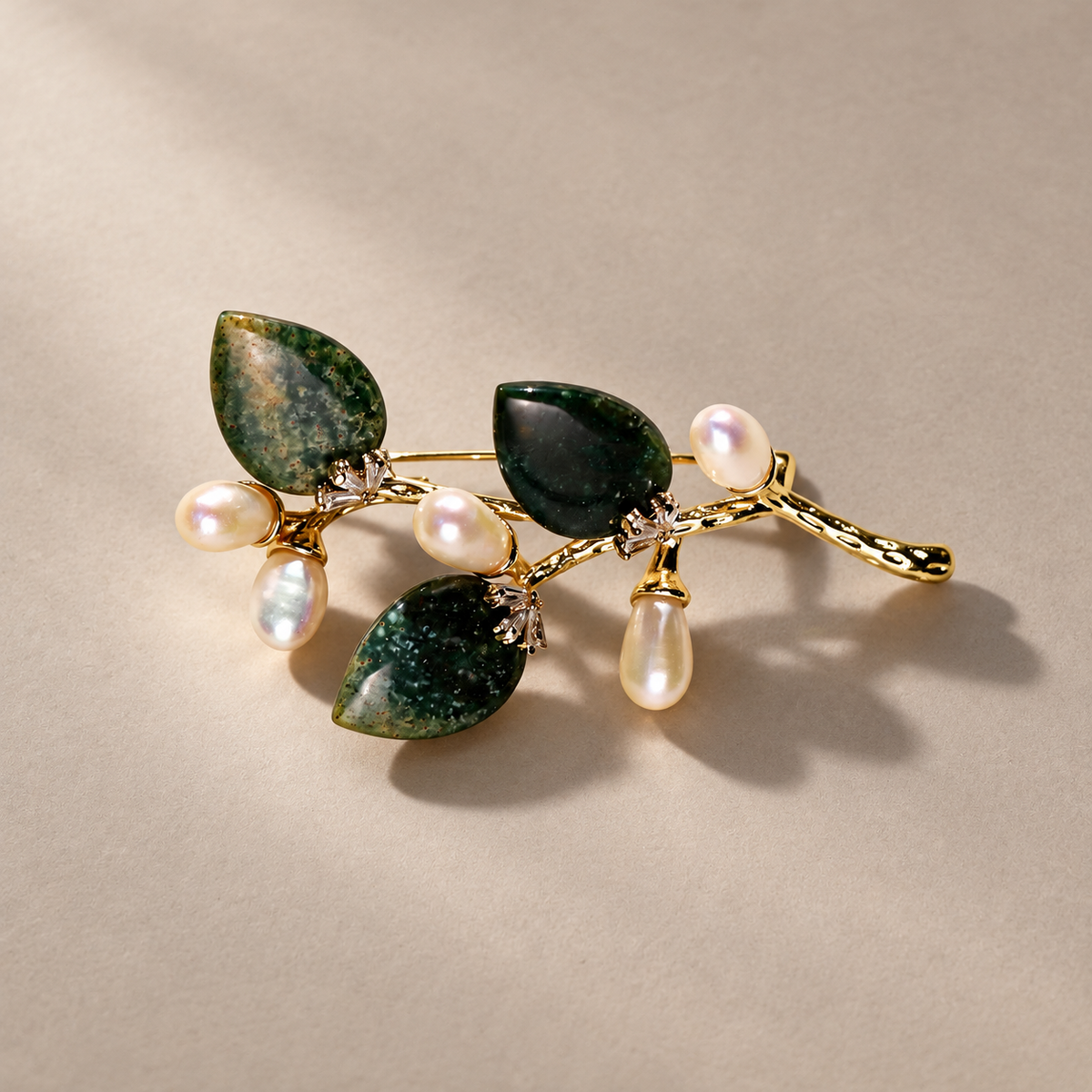 Dark Green natural stone flower branch brooch with freshwater pearls on a neutral background