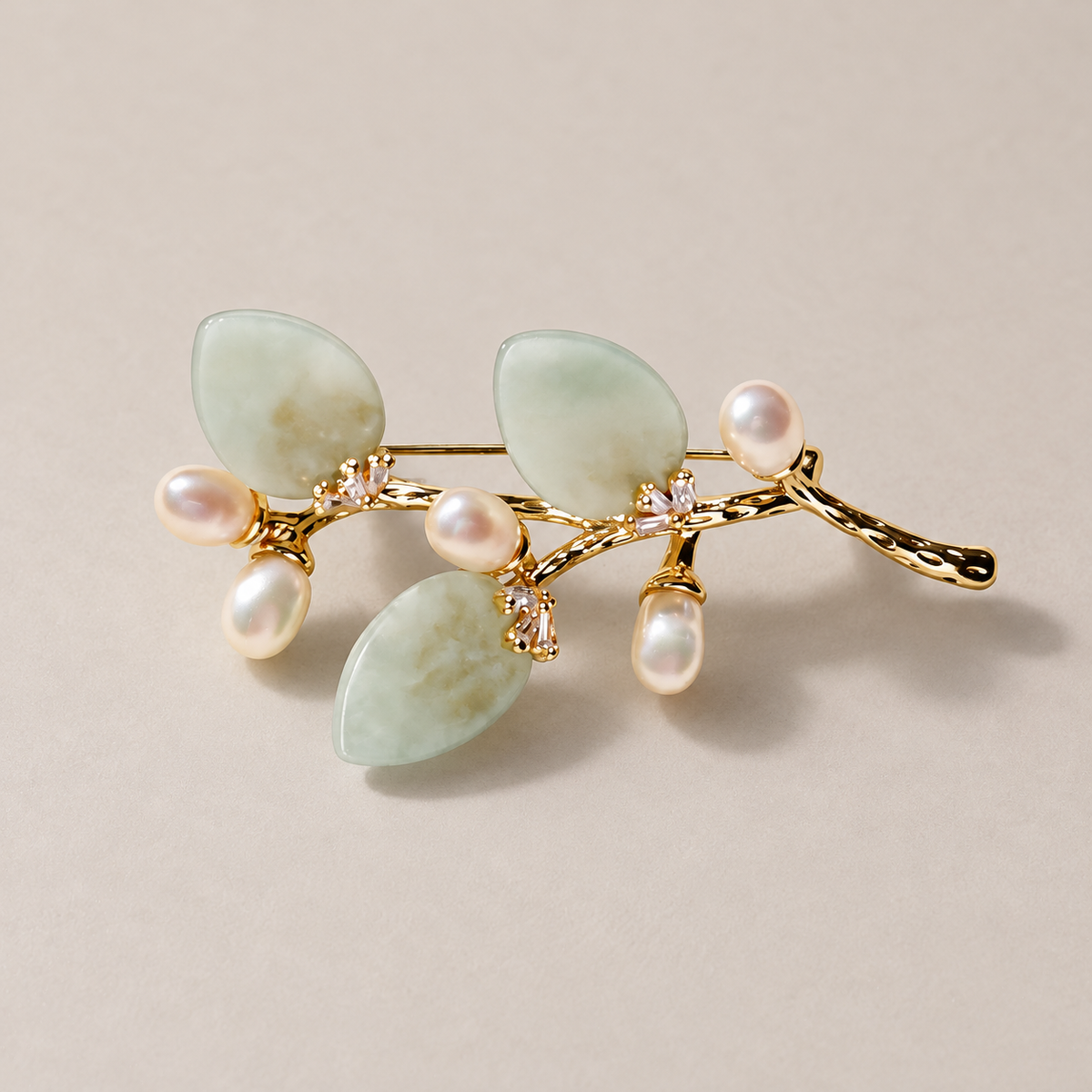Light Green natural stone flower branch brooch with freshwater pearls on a neutral background