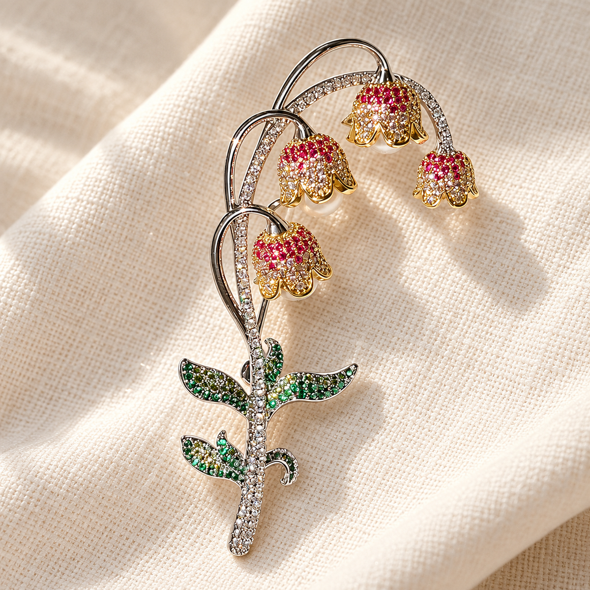 Lily of the valley brooch with mixed-tone white bead drops, tabletop view