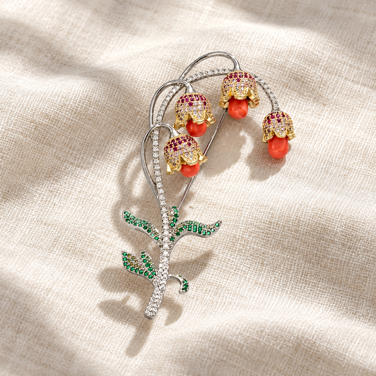 Lily of the valley brooch with mixed-tone red stone drops, tabletop view