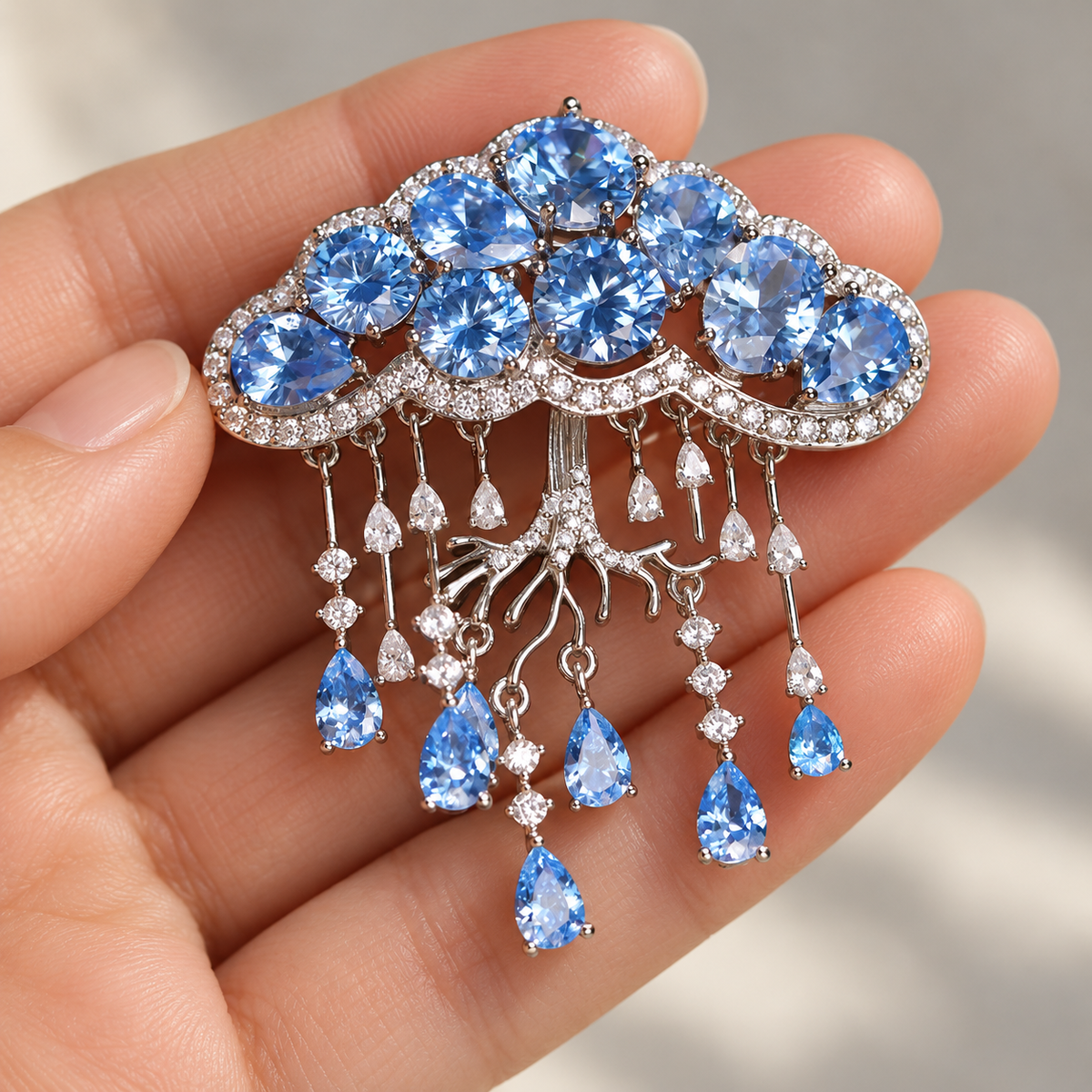 Light Blue Cloud cloud tassel brooch and pendant held in a hand