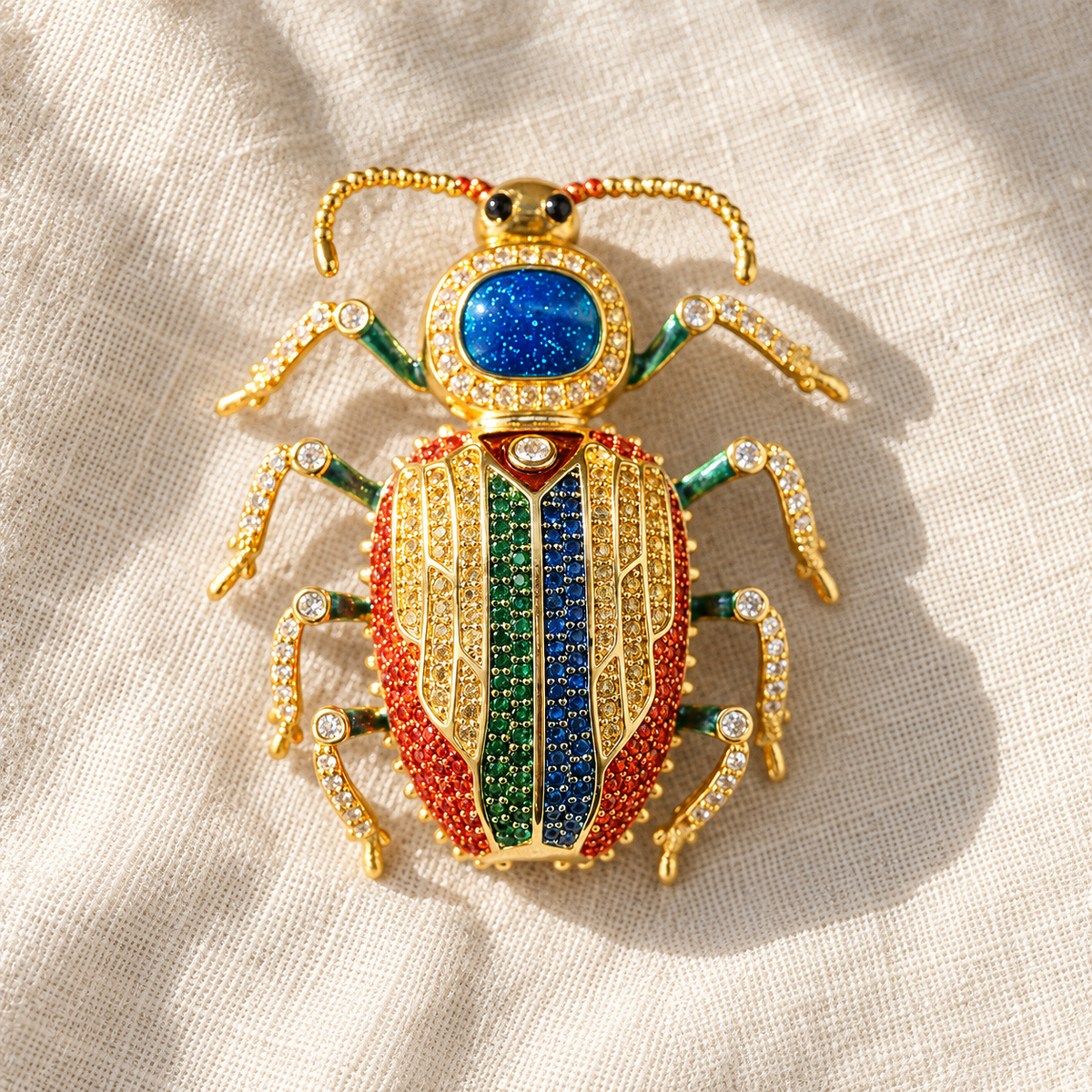 Multicolor beetle brooch on light fabric