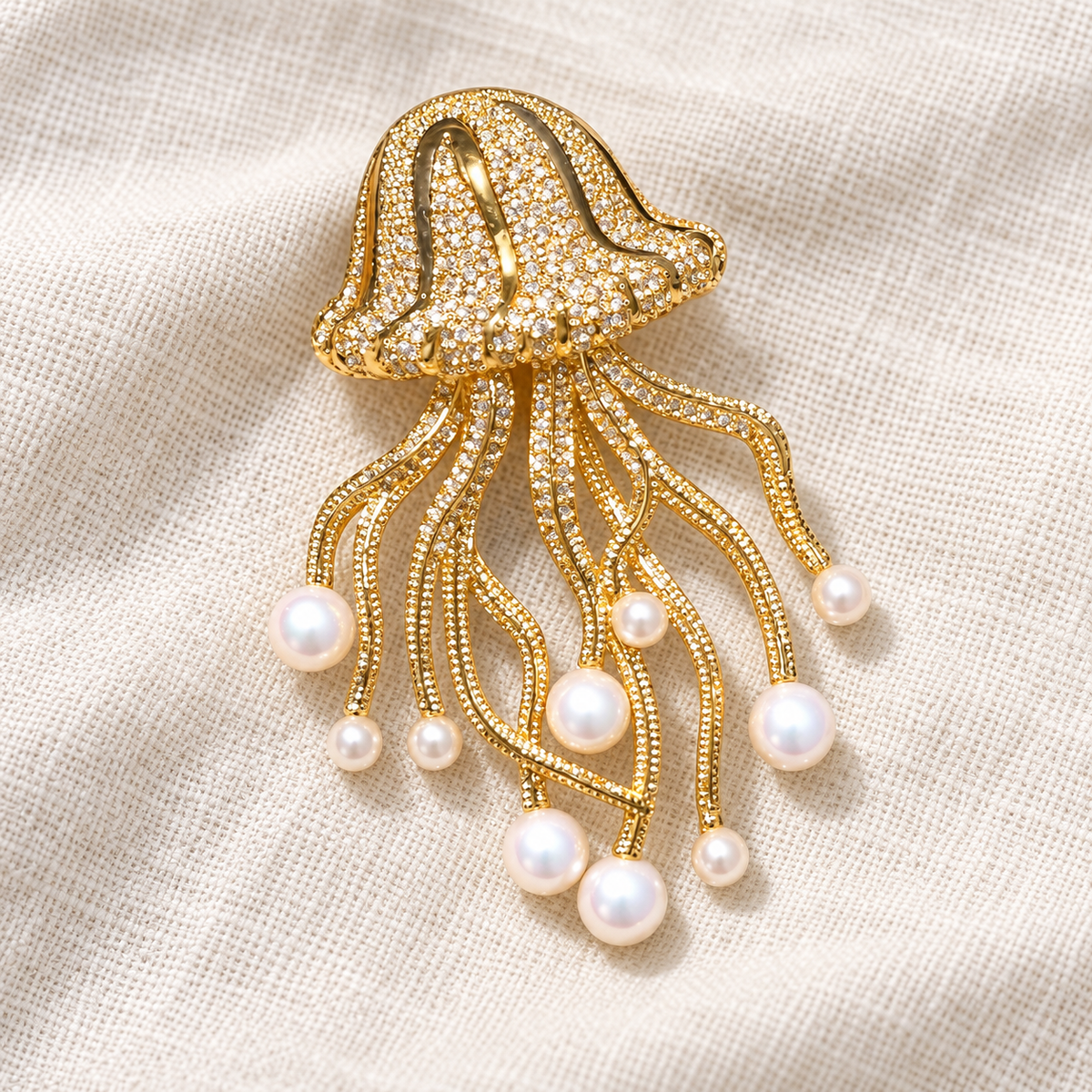 Gold-tone shell pearl jellyfish brooch in a tabletop setting
