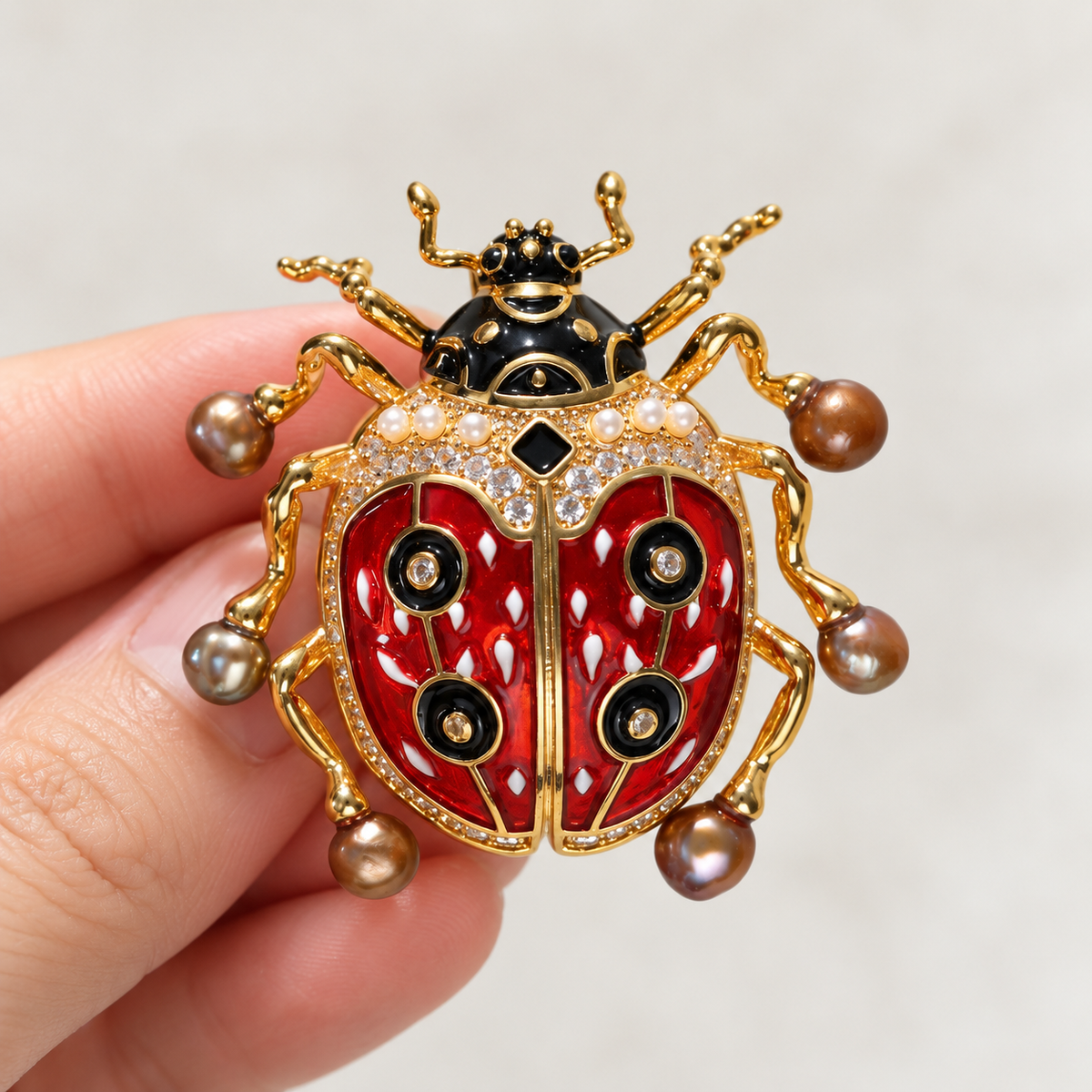 Baroque Pearl ladybug brooch held in a hand