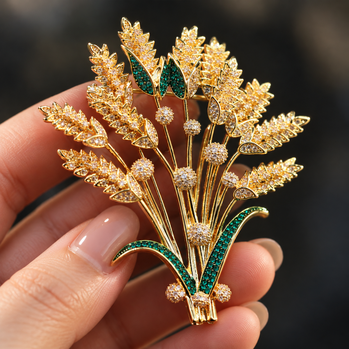 Gold tone wheat sheaf brooch held in a hand