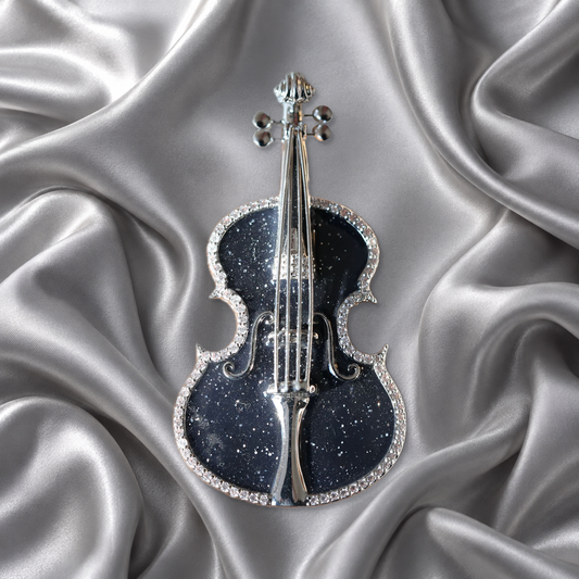 Black violin brooch with silver-tone details on silver-grey satin