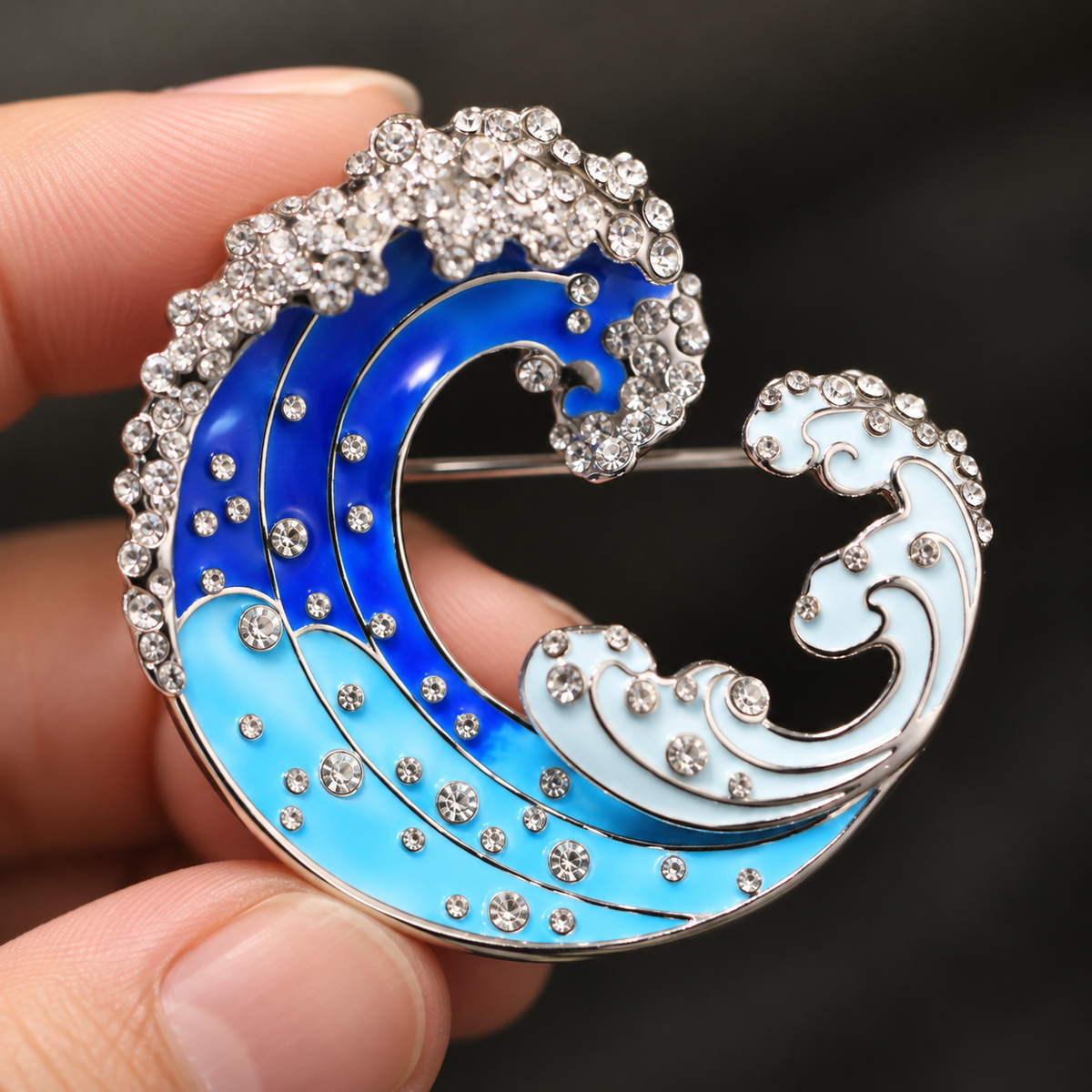 Blue Gradient Wave brooch held in a hand