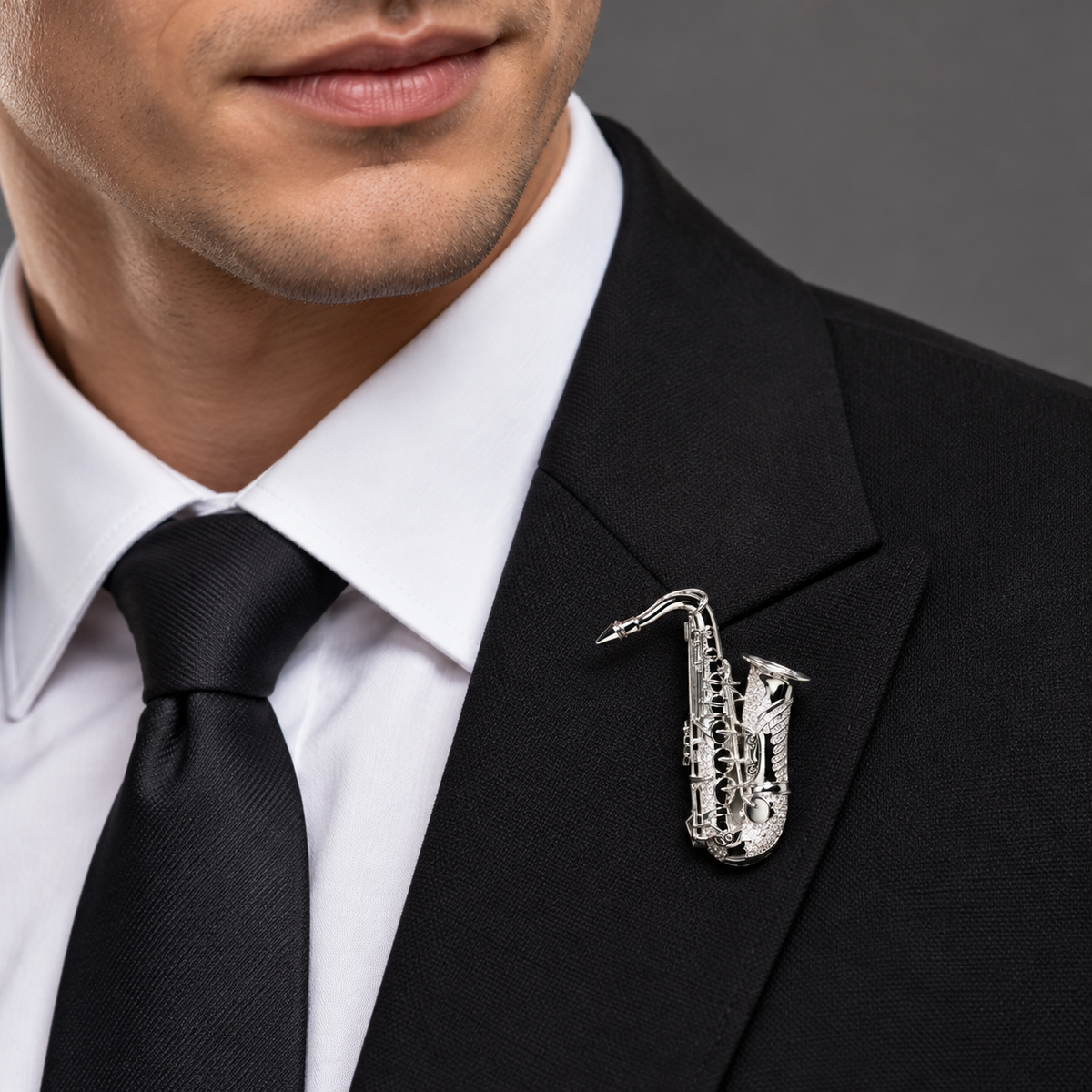 Silver tone saxophone brooch worn on a black suit lapel
