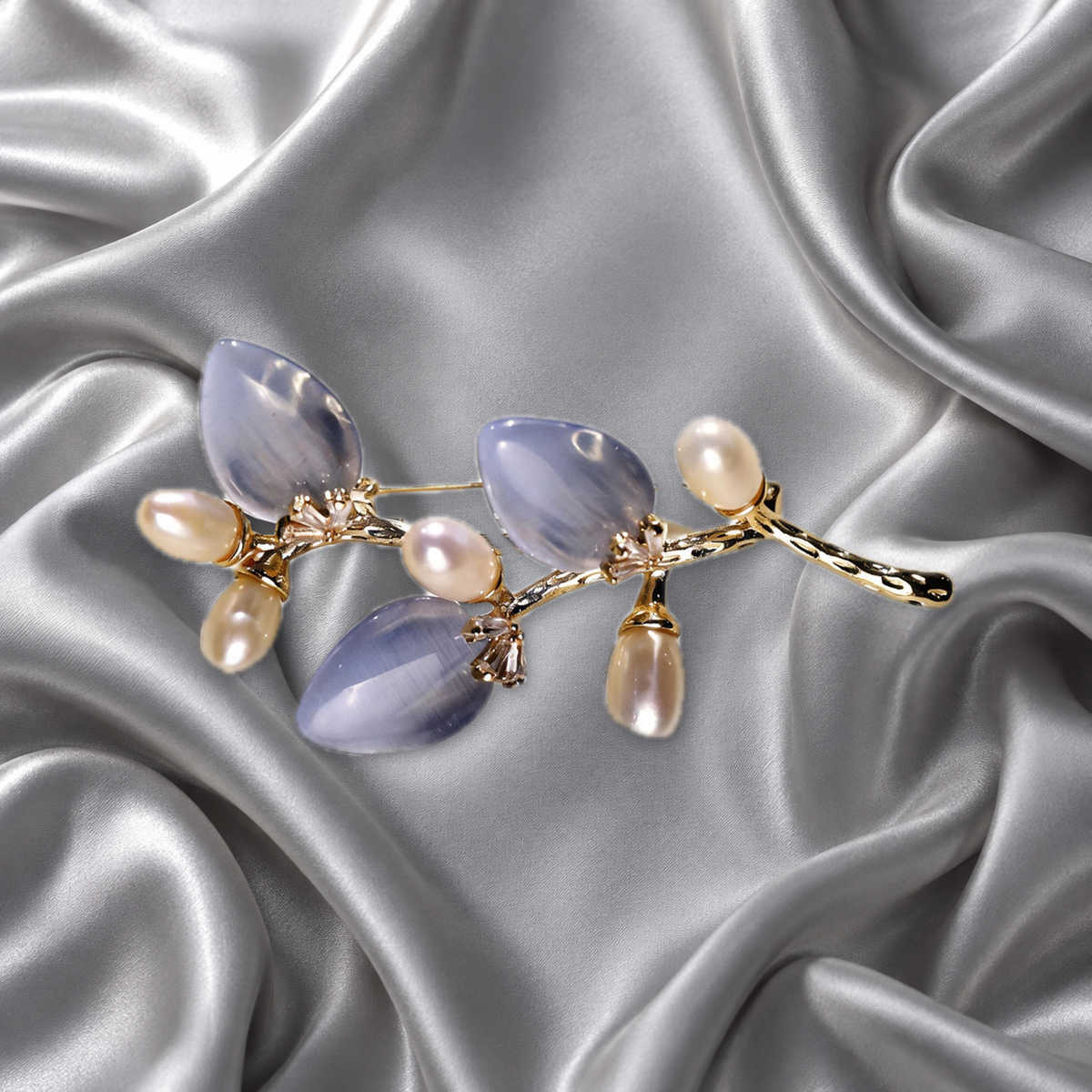 Blue cat-eye stone flower branch brooch with freshwater pearls on silver-grey satin