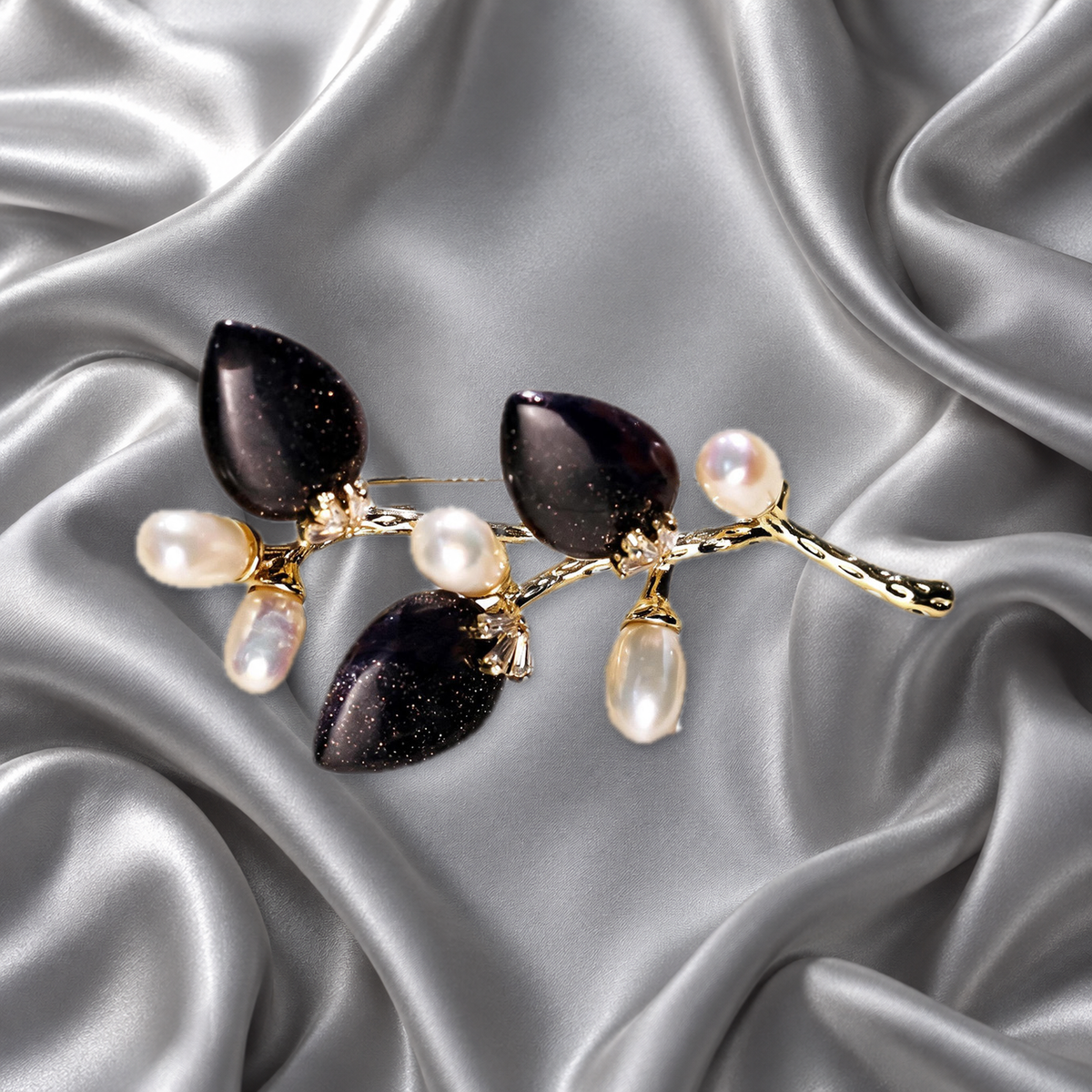 Black natural stone flower branch brooch with freshwater pearls on silver-grey satin