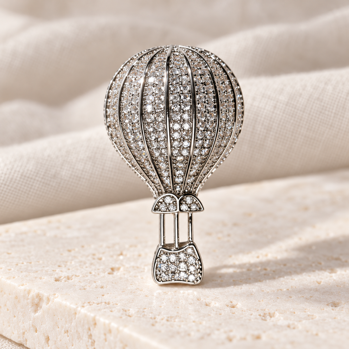 Silver hot air balloon brooch and pendant in a styled tabletop display