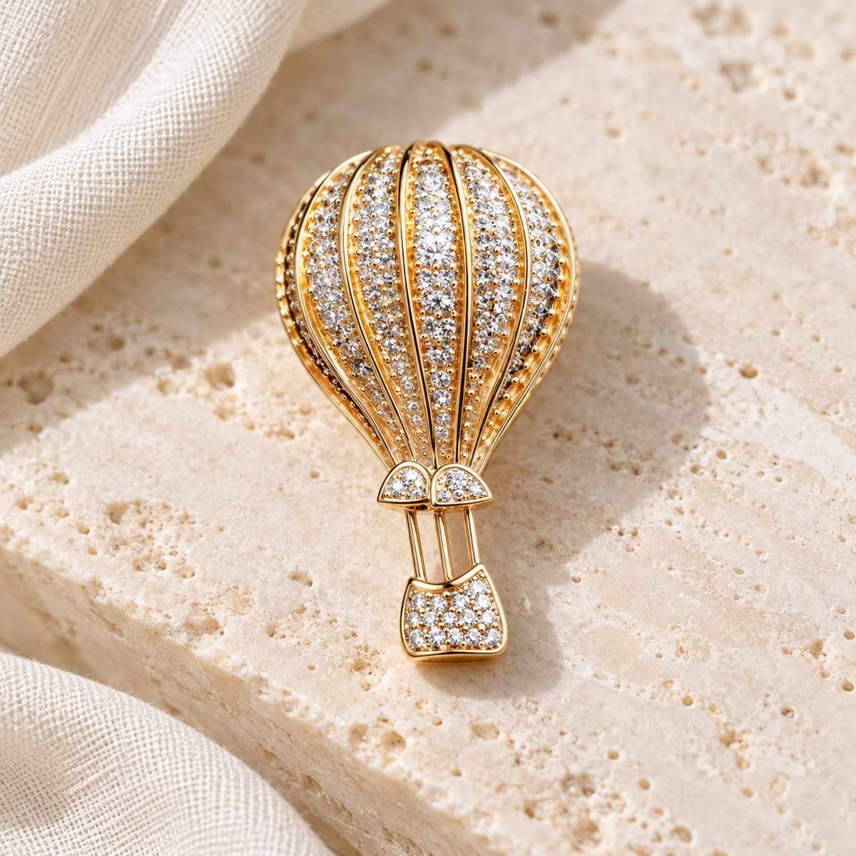 Gold hot air balloon brooch and pendant in a styled tabletop display