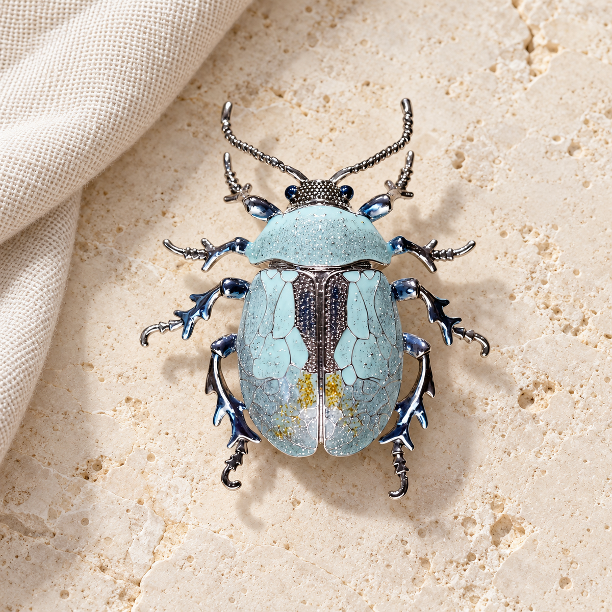 Blue enamel beetle brooch, styled tabletop display
