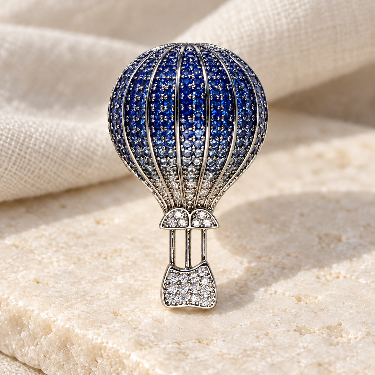 Silver Blue hot air balloon brooch and pendant in a styled tabletop display