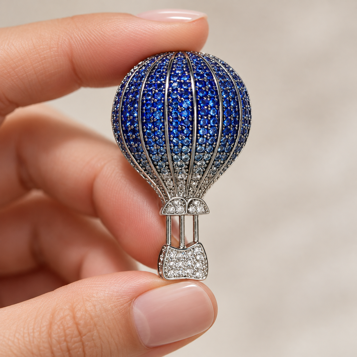 Silver Blue hot air balloon brooch and pendant held in a hand