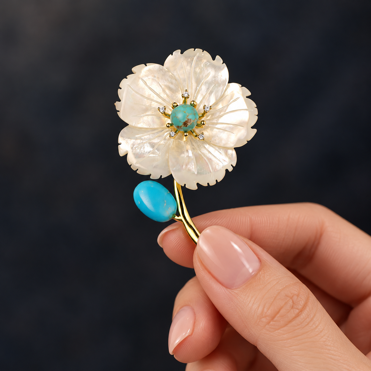 Blue shell flower brooch held in a hand
