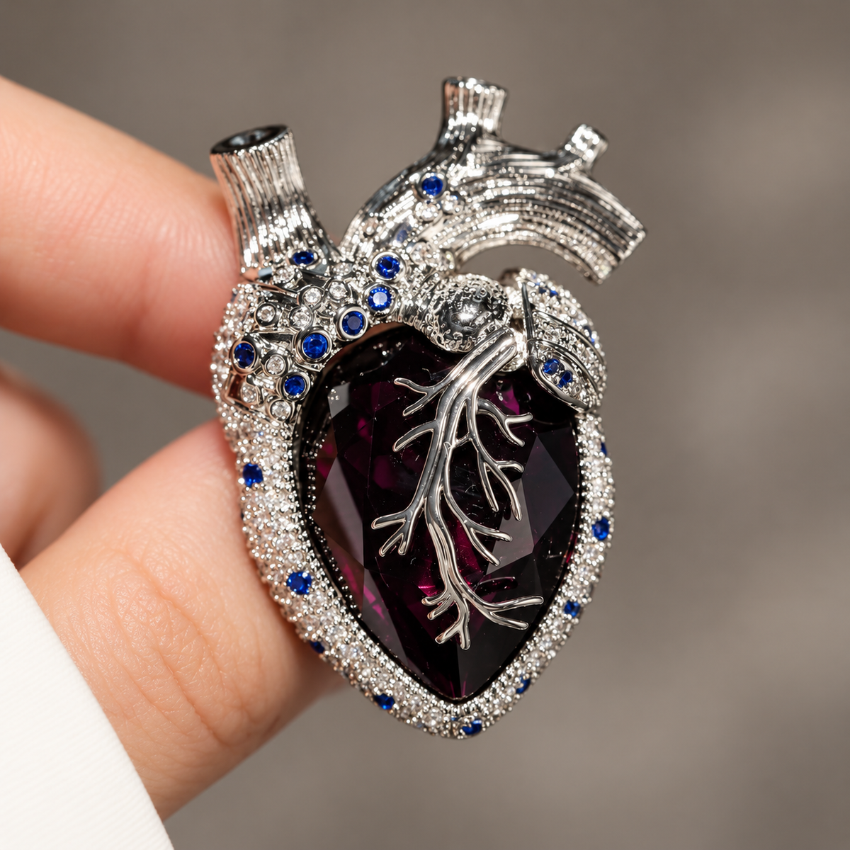 Silver Tone Purple with Blue Accents anatomical heart brooch held in a hand