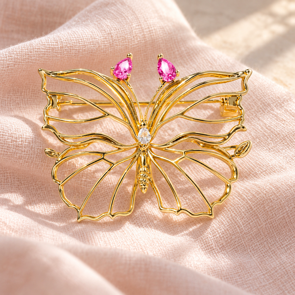 Rose Pink openwork butterfly brooch displayed on blush fabric