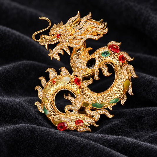 Dragon brooch, front view with curled gold-tone body and red, green, and dark accents