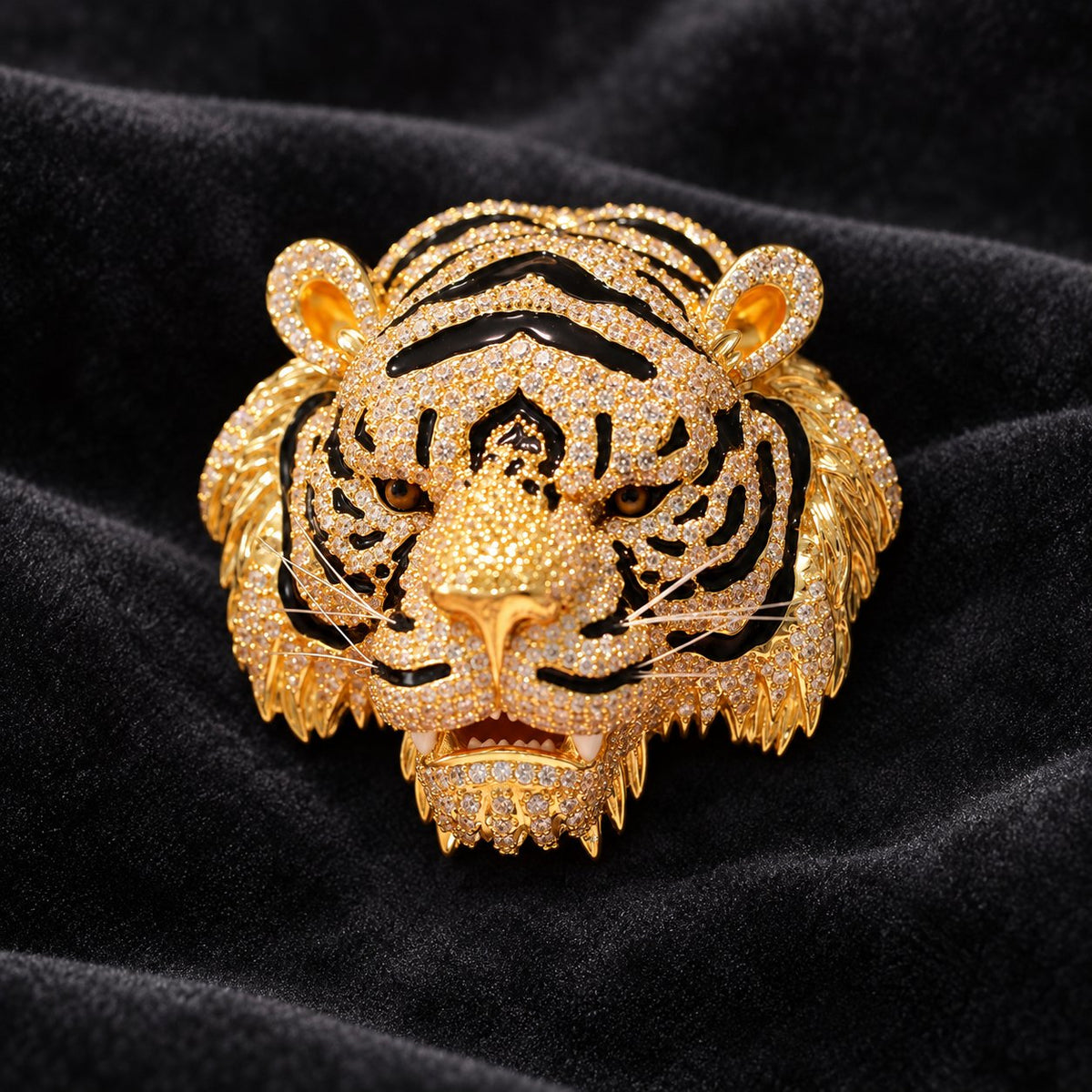 Gold-tone tiger head brooch with dark stripes, amber-colored eyes and bright accents