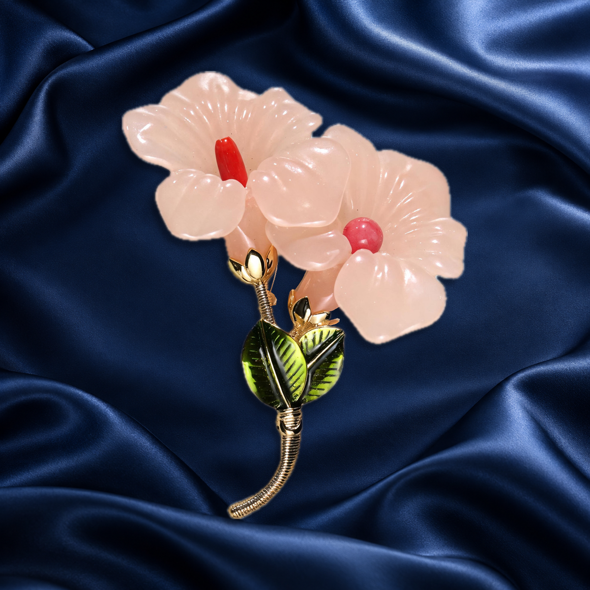 Pale pink flower brooch with red centers on navy satin