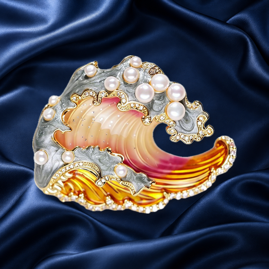 Orange enamel wave brooch with pearls and gold-tone border on navy satin
