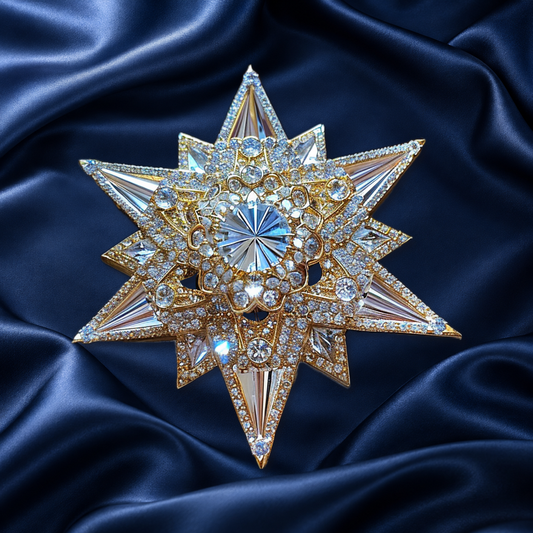 Gold-tone layered starburst brooch with a faceted center and sparkling accents on navy satin